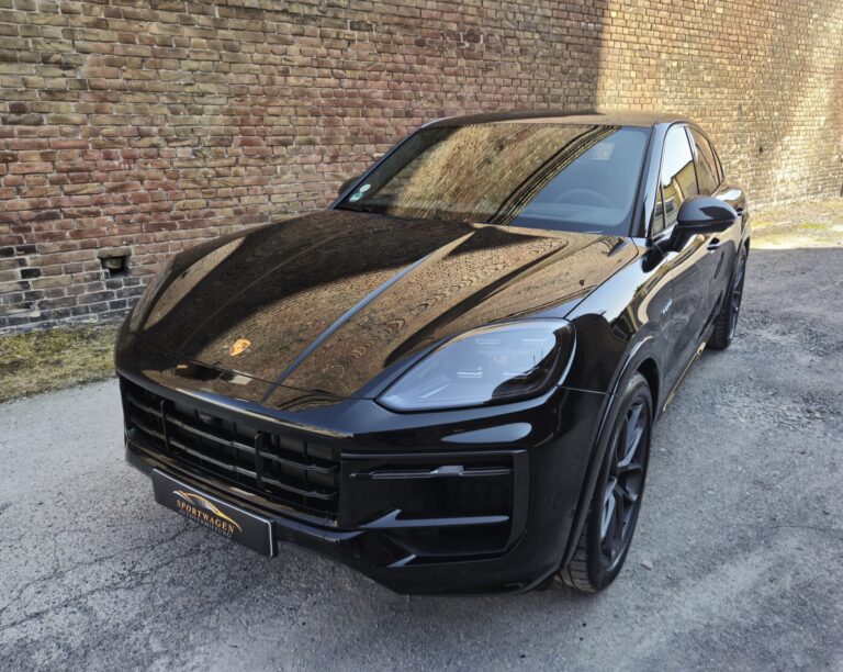 Porsche Cayenne in Schwarz, Frontansicht gerade, vor einem Backsteingebäude