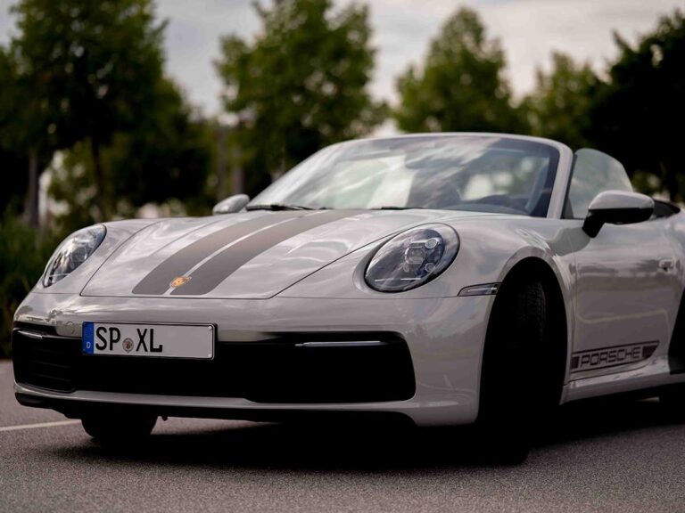 Porsche 911 in Grau, Frontansicht gerade, auf einem Parkplatz