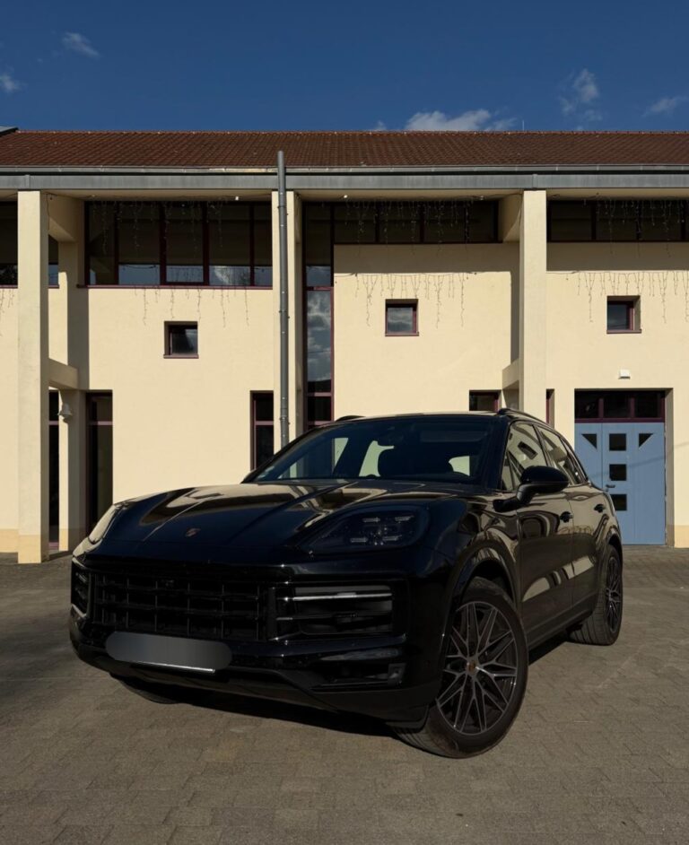 Porsche Macan in Schwarz, Frontansicht schräg links, vor einem Gebäude